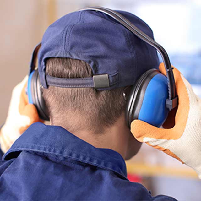 Person Holds Safety Ear Muffs On Head